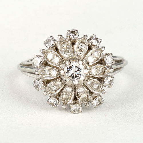 47 - AN 18 CARAT WHITE GOLD DIAMOND CLUSTER RING
The illusion set stones with the largest to the centre, ... 