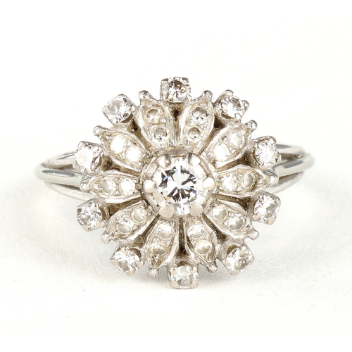 47 - AN 18 CARAT WHITE GOLD DIAMOND CLUSTER RING
The illusion set stones with the largest to the centre, ... 