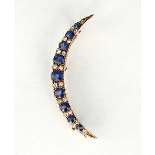 5 - AN EDWARDIAN 15 CARAT GOLD SAPPHIRE AND DIAMOND CRESCENT SHAPE BROOCH
The nine graduated oval sapphi... 