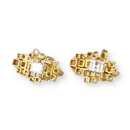 9 - A PAIR OF 18 CARAT GOLD EAR CLIPS, EACH CENTRED BY AN EMERALD CUT DIAMOND
Composed of irregular open... 