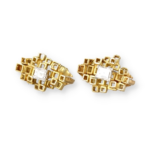 9 - A PAIR OF 18 CARAT GOLD EAR CLIPS, EACH CENTRED BY AN EMERALD CUT DIAMOND
Composed of irregular open... 