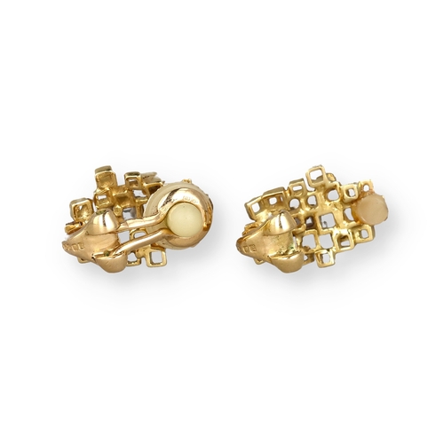 9 - A PAIR OF 18 CARAT GOLD EAR CLIPS, EACH CENTRED BY AN EMERALD CUT DIAMOND
Composed of irregular open... 