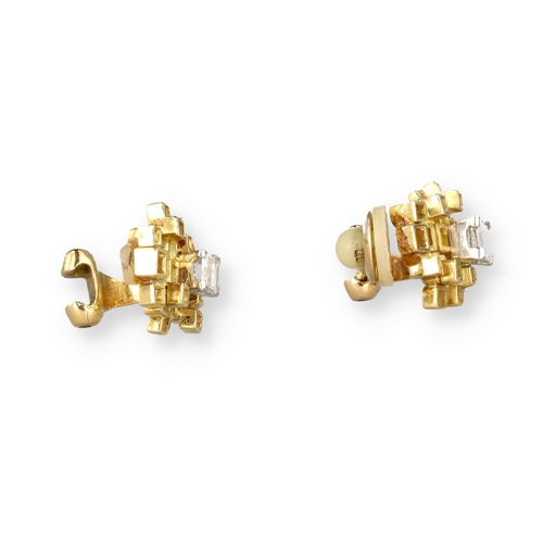 9 - A PAIR OF 18 CARAT GOLD EAR CLIPS, EACH CENTRED BY AN EMERALD CUT DIAMOND
Composed of irregular open... 