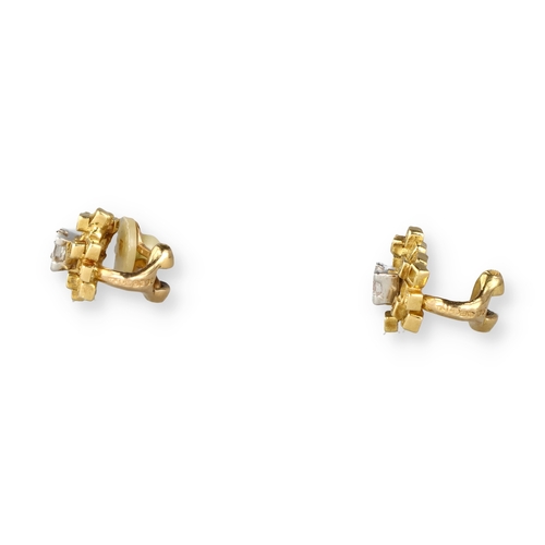 9 - A PAIR OF 18 CARAT GOLD EAR CLIPS, EACH CENTRED BY AN EMERALD CUT DIAMOND
Composed of irregular open... 