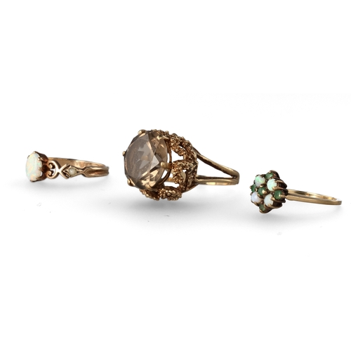 39 - A GROUP OF THREE 9 CARAT GOLD STONE SET DRESS RINGS
The first with a smokey quartz in a raised abstr... 
