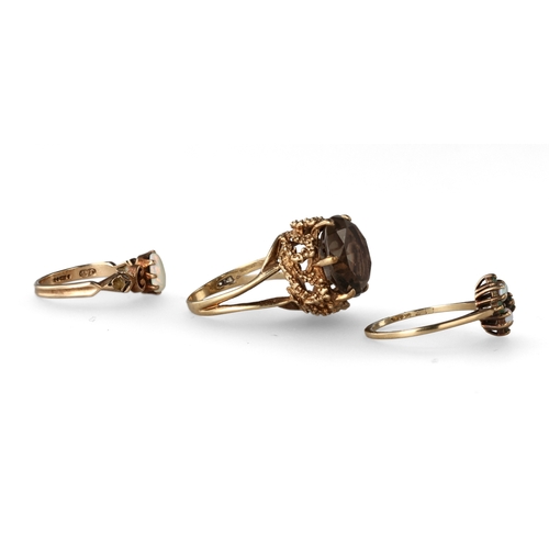 39 - A GROUP OF THREE 9 CARAT GOLD STONE SET DRESS RINGS
The first with a smokey quartz in a raised abstr... 