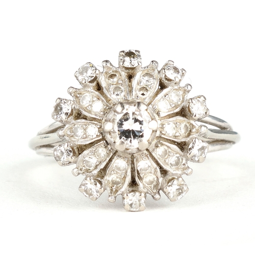 41 - AN 18 CARAT WHITE GOLD DIAMOND CLUSTER RING
The illusion set stones with the largest to the centre, ... 