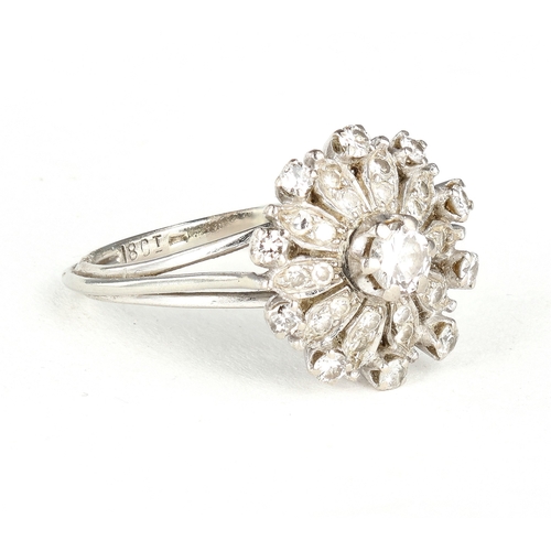41 - AN 18 CARAT WHITE GOLD DIAMOND CLUSTER RING
The illusion set stones with the largest to the centre, ... 