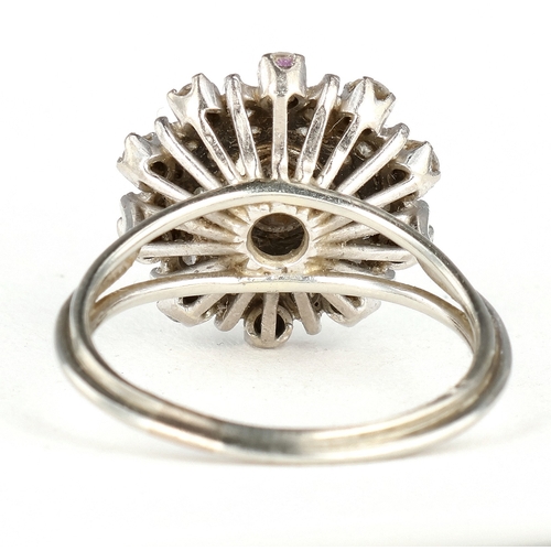 41 - AN 18 CARAT WHITE GOLD DIAMOND CLUSTER RING
The illusion set stones with the largest to the centre, ... 
