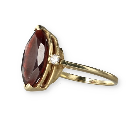 49 - A 14 CARAT GOLD GARNET AND DIAMOND THREE-STONE DRESS RING
The marquise cut garnet flanked by two bri... 