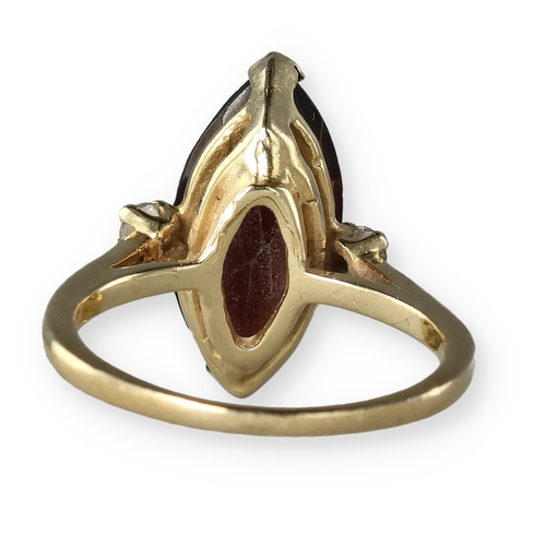 49 - A 14 CARAT GOLD GARNET AND DIAMOND THREE-STONE DRESS RING
The marquise cut garnet flanked by two bri... 