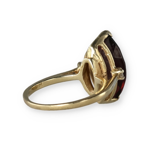 49 - A 14 CARAT GOLD GARNET AND DIAMOND THREE-STONE DRESS RING
The marquise cut garnet flanked by two bri... 