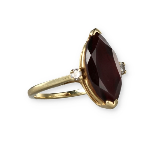 49 - A 14 CARAT GOLD GARNET AND DIAMOND THREE-STONE DRESS RING
The marquise cut garnet flanked by two bri... 