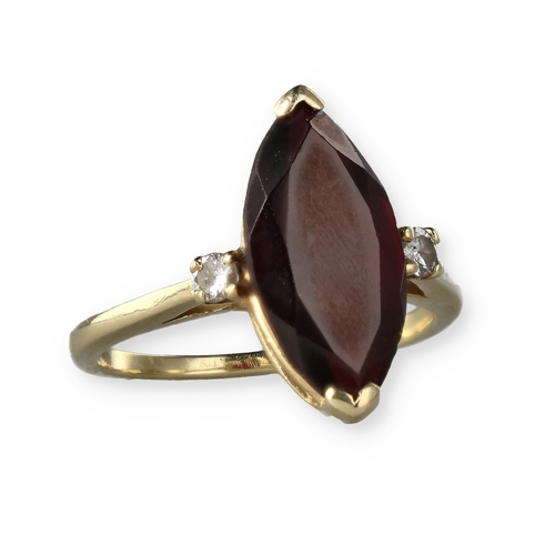 49 - A 14 CARAT GOLD GARNET AND DIAMOND THREE-STONE DRESS RING
The marquise cut garnet flanked by two bri... 