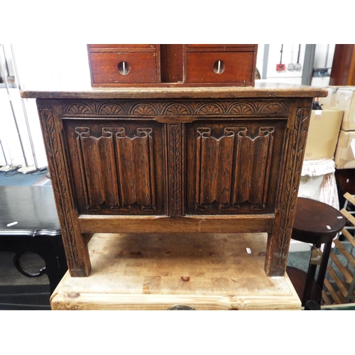 603 - A small 20thC oak coffer the two plank top over an arcade and linen fold carved front