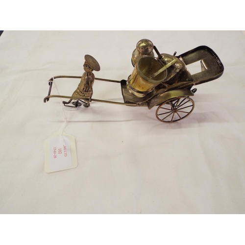 102 - A Chinese white metal three piece cruet in the form of a rickshaw and driver