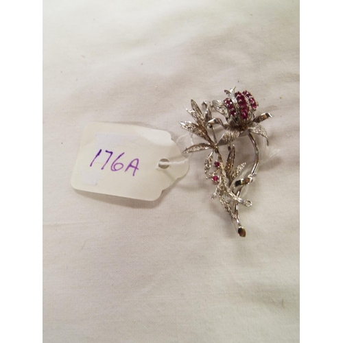 176A - A 9ct white gold brooch in the form of a flower and foliage inset with rubies total weight 11.1g