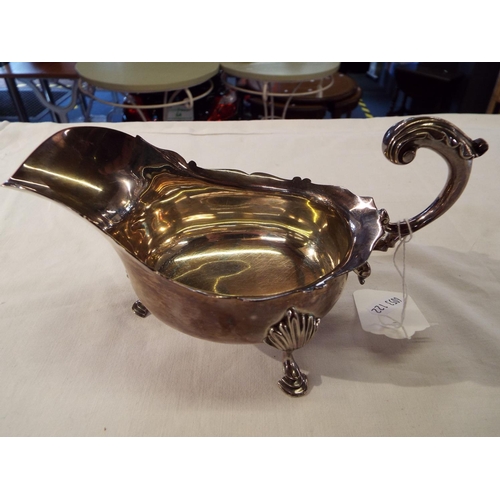 121 - A London 1900 silver sauce boat having cut rim scroll handle resting on three hoof feet 8.60 oz