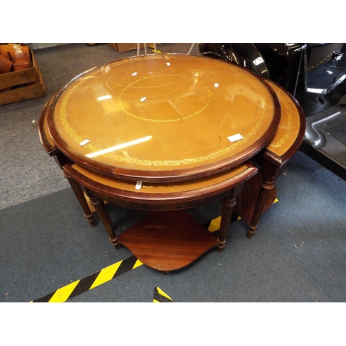 180 - A nest of five tables with tan leather and glass insets