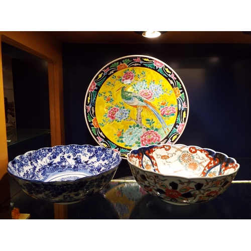 41 - A large Oriental charger having peacock decoration together with two oriental bowls