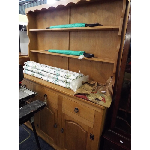 437 - A light oak dresser the top having two plate racks above three short drawers with cupboards under