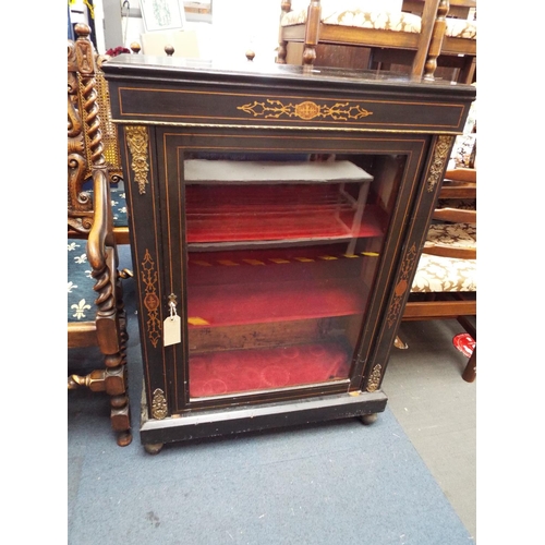 550 - An ebonised pier cabinet having satin wood inlay ormolu mounts, the glazed doors enclosing two velve... 