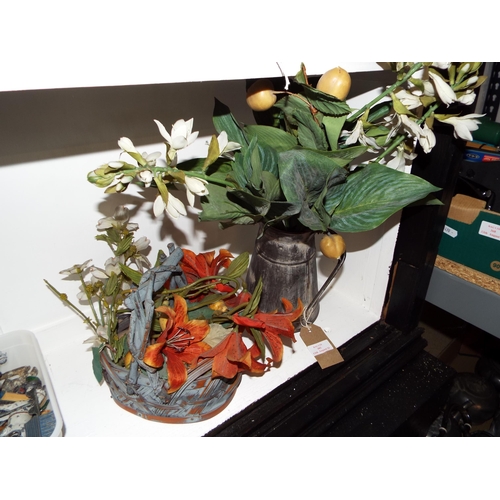 382 - A galvanised water jug with artificial flowers and a wicker basket with artificial flowers