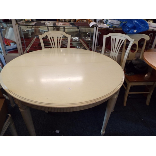 732 - A cream painted extending dining table and four matching chairs