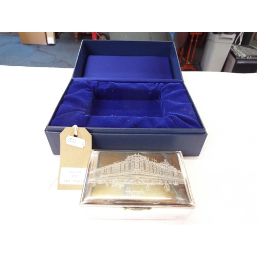 131 - A Harrod's silver plated cigarette box with engraved picture of the corner shop