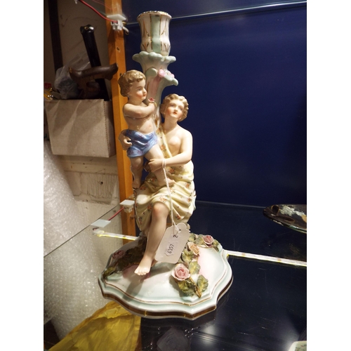 63 - A porcelain candelabra depicting a female with child A/F to flowers