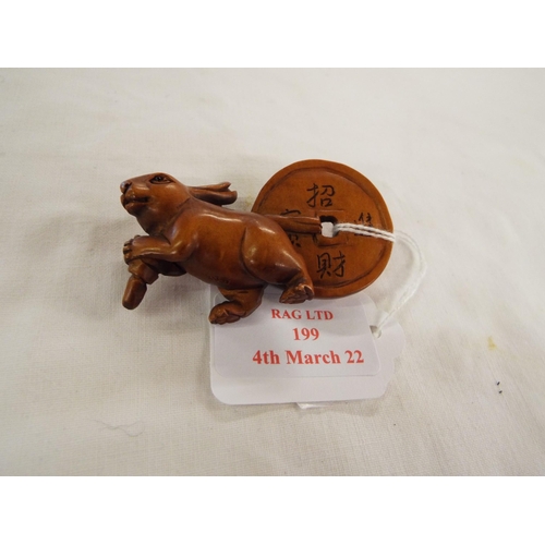 199 - A hand carved boxwood netsuke hare with disk, signed