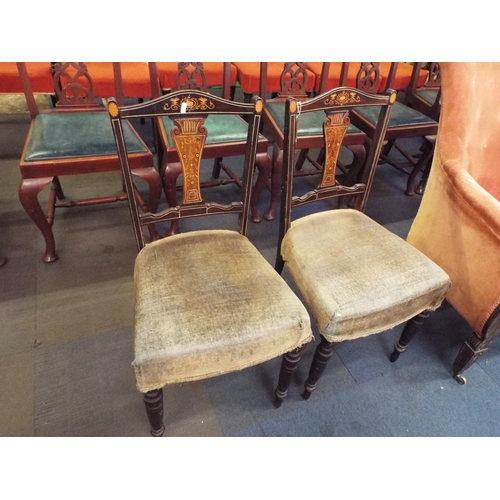 616 - A pair of Edwardian mahogany and satinwood inlaid chairs resting on turned supports