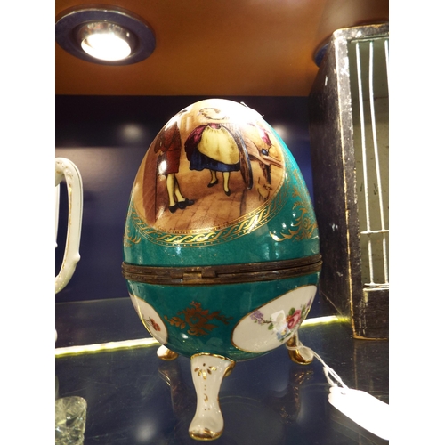 89 - A large porcelain decorative egg with Cries of London pictorial panels resting on three legs