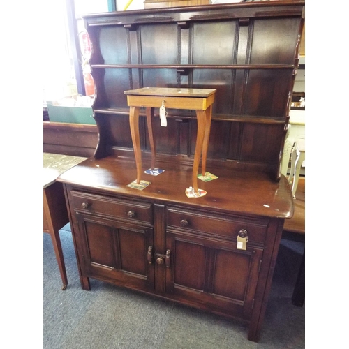 An Ercol dark wood dresser the top having two plate racks above two short drawers and cupboard under