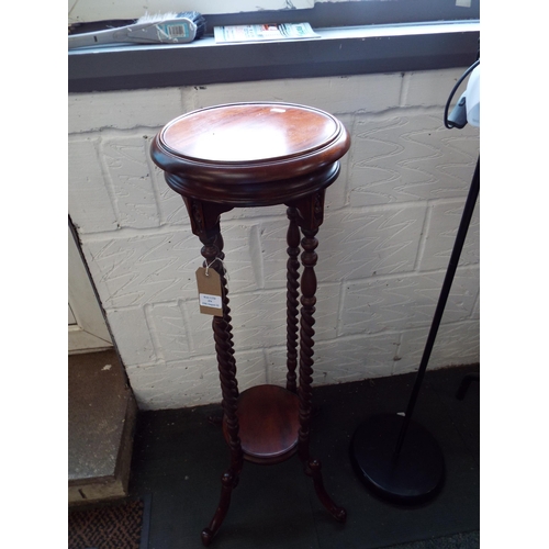 454 - A mahogany torchere having barley twist pillars resting on four splayed legs