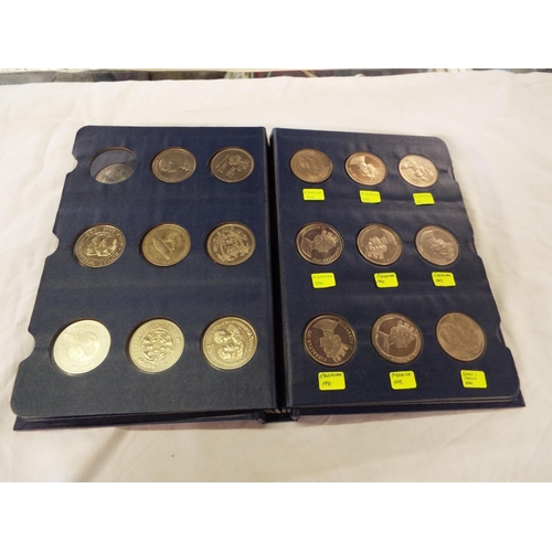 111 - A coin library album containing forty two crowns and coins to include New Zealand, Guernsey, S. Rhod... 