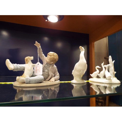 18 - A Nao figurine 'Boy Playing With His Dog' and two Nao figurines depicting a 'Swan' and 'Three Geese'