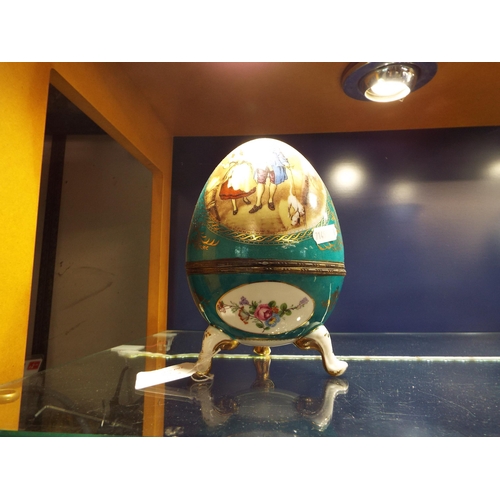42 - A large porcelain decorative egg with Cries of London pictorial panels resting on three legs