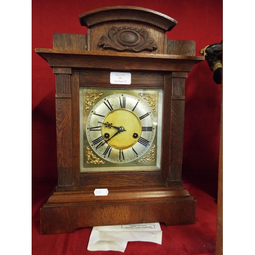 193 - An oak cased mantel clock the dial having Roman numerals, striking on a gong plaque to top S.E.C.R S... 