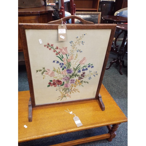 494 - An oak framed embroidered fire screen with floral pattern