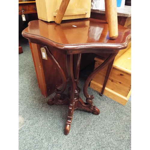 514 - A mahogany scallop shaped table with scroll work stretchers and supports