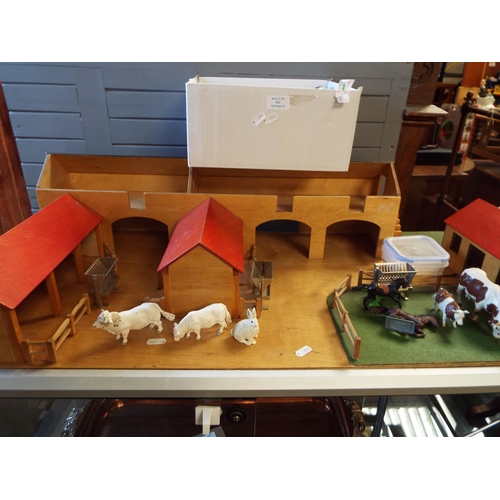 582 - A child's wooden farm set with a good selection of Britain's farm animals etc