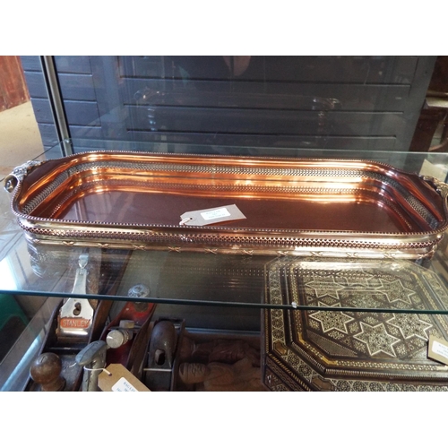 583 - A copper drinks tray with scroll handles and pierced sides