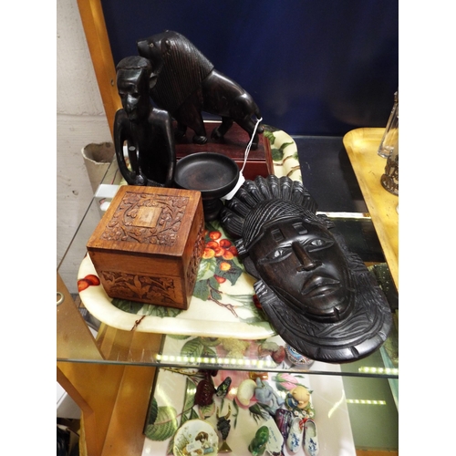 57 - A selection of carved ebony items to include lion, figure, mask and lidded pot