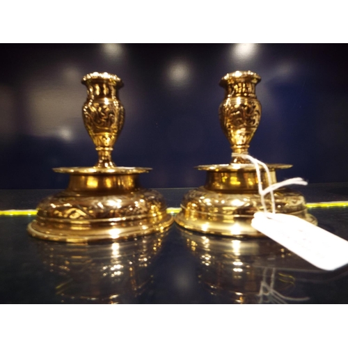 83 - A pair of Victorian short brass candlesticks with engraved decoration