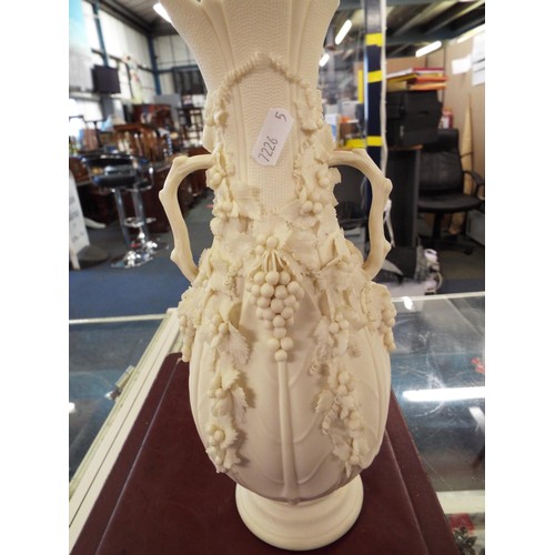 49 - A Parian-ware vase with applied grape and vine and a figurine