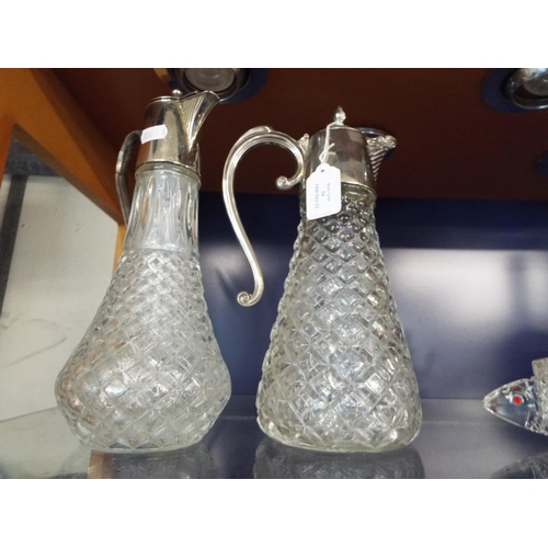 54 - Two white metal and glass claret jugs