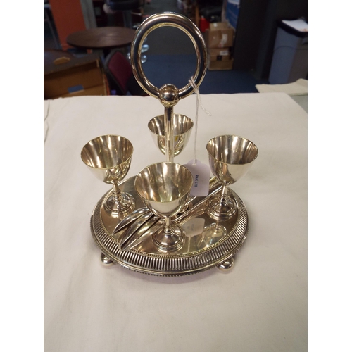 149 - A silver-plated egg cruet with spoons