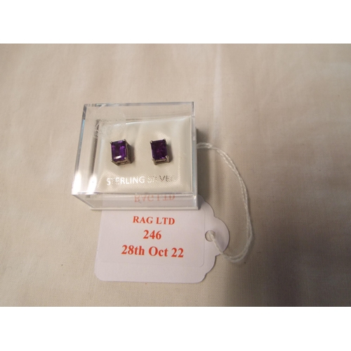 246 - A pair of sterling silver earrings inset with purple stones