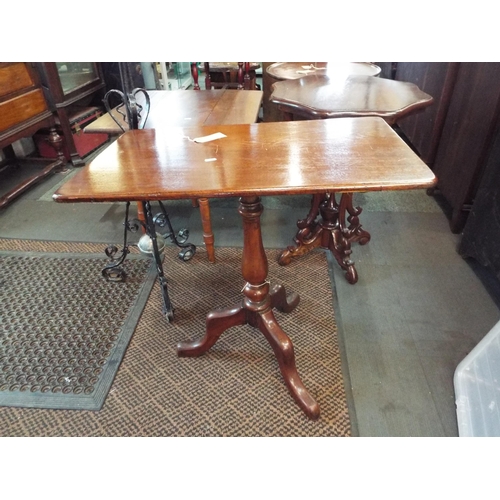 640 - A mahogany oblong snap top side table resting on tri-form base